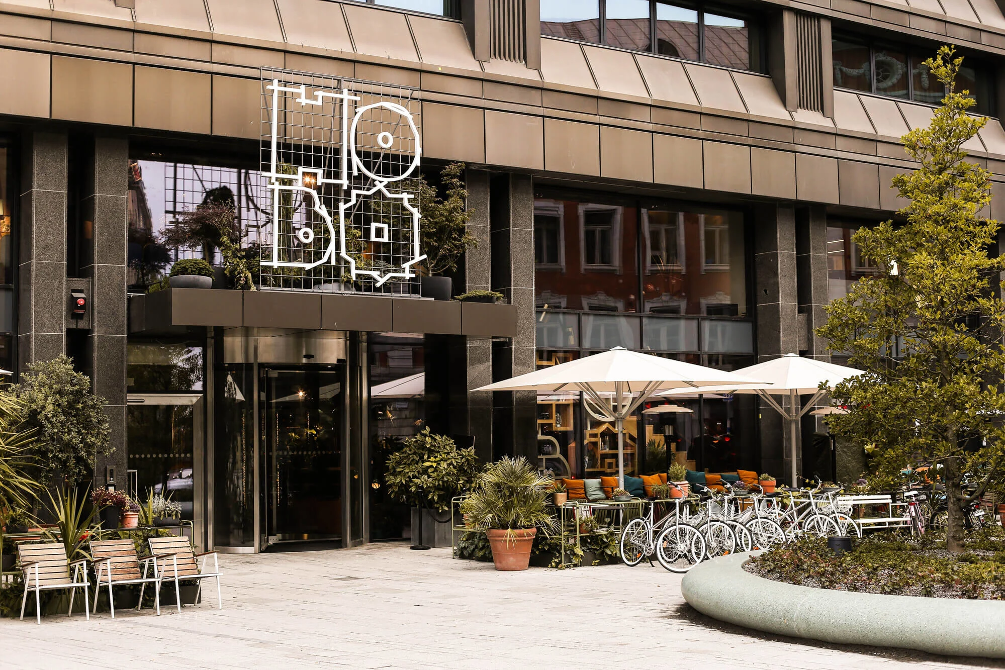 HotellstÃ¤dning Stockholm - Modern hotellfasad med uteservering